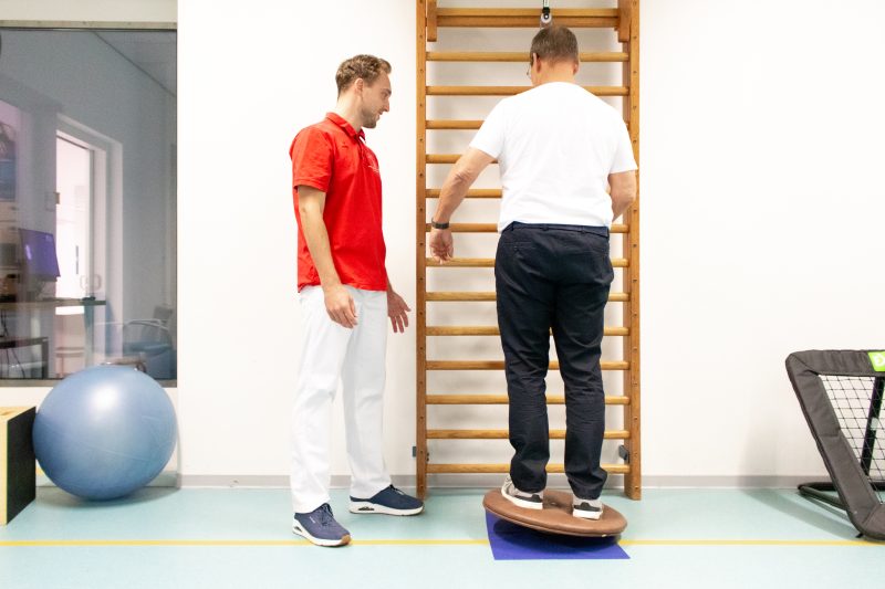 Begeleiding bij een oefening met een balansplank.